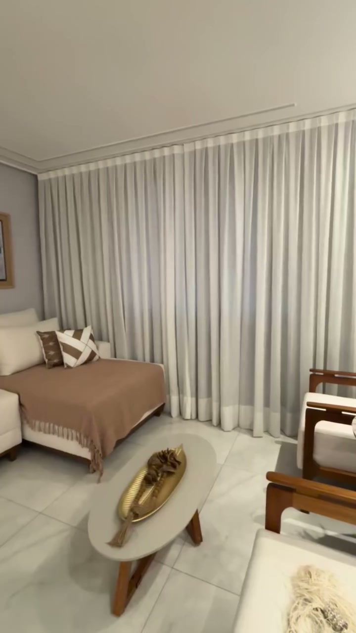Sala de estar com cortina clara e sofá bege